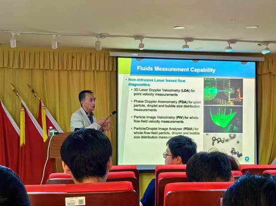 A person standing in front of a screen
Description automatically generated